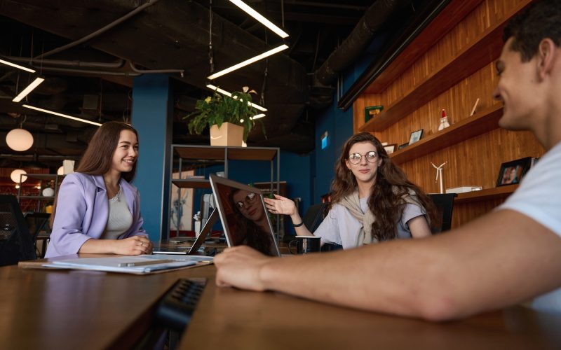 Friendly office team discussing workflow at a table in office